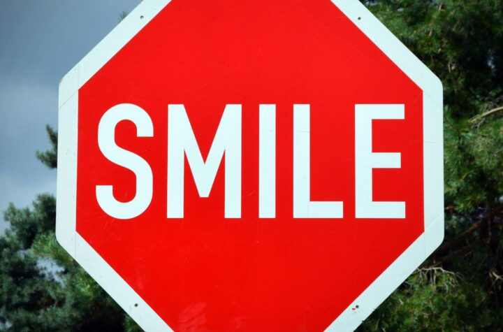 A red stop sign with the word "SMILE" instead of "stop." Smile, good mood, bad mood, emotions.